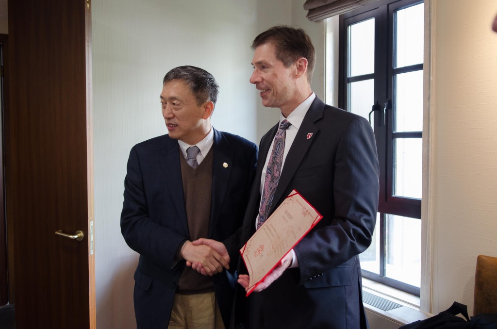 Dr. Gang Pei, president of Tongji University, presents certificate to Dr. Kyle Meyer.