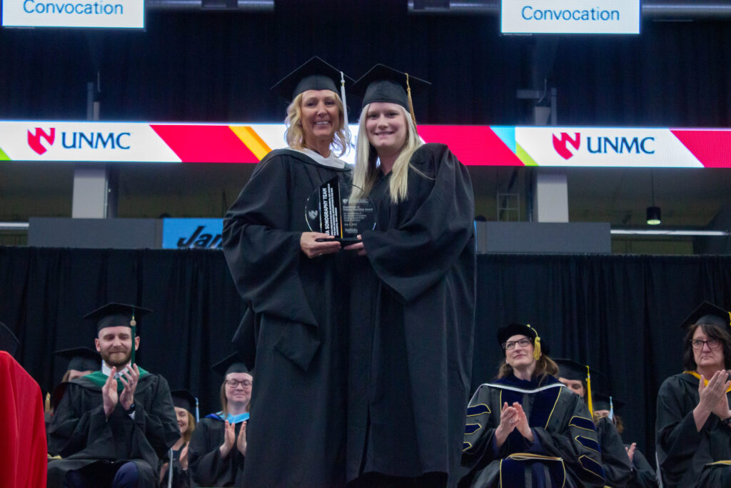 Jessica Mueller accepts the Excellence in Clinical Teaching Award from Kim Michael on behalf of the VA Sonography Team.