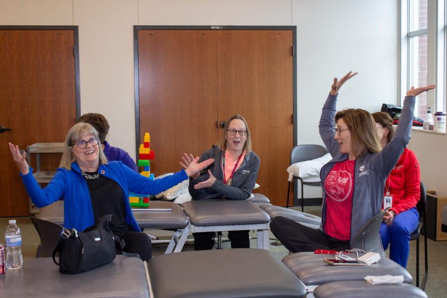Faculty throw their arms in the air to celebrate completion of a Lego tower&period;