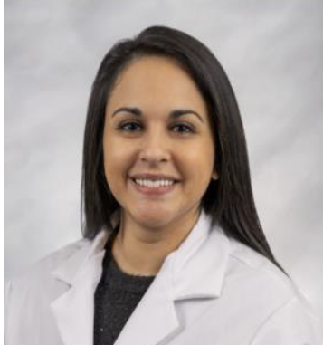 Headshot of a healthcare professional wearing a white lab coat against a gray background.