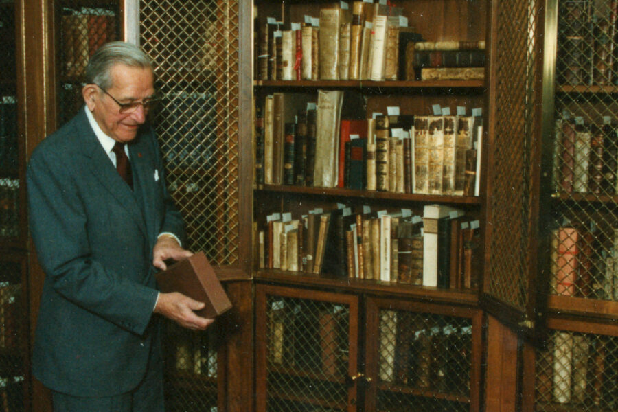 Dr&period; McGoogan in the North Rare Book Room viewing a book that has a protective casing on it