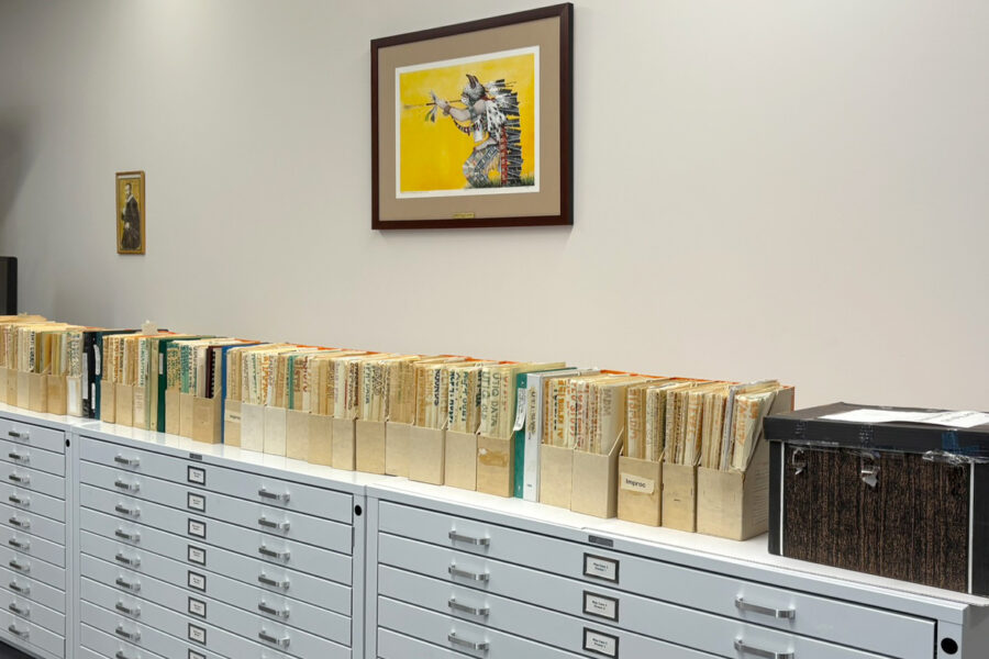 Magazine file folders set out across a large filing table in the archives room