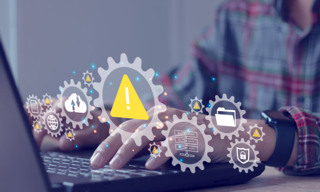 Man in plaid shirt typing on laptop. Animated gears showing warning, folder, lock and cloud refresh laid on top of image.