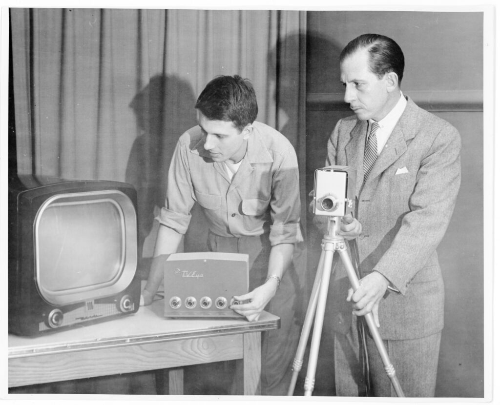 Photograph of Dr. Cecil Wittson with Nebraska Psychiatric Institute staff member adjusting closed circuit television (CCTV) equipment. Black and White. Undated